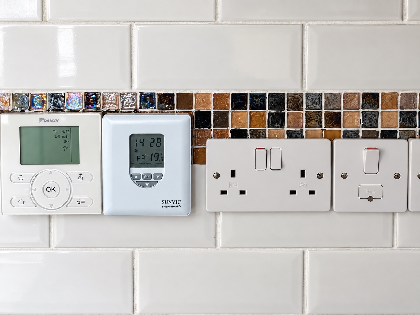 Domestic electrical controls, sockets and fused connection unit installed on a tiled wall